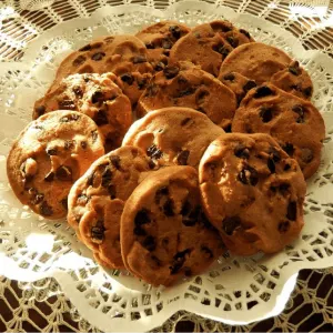 A lace-covered plate holding Oatmeal Chocolate Chip cookies.