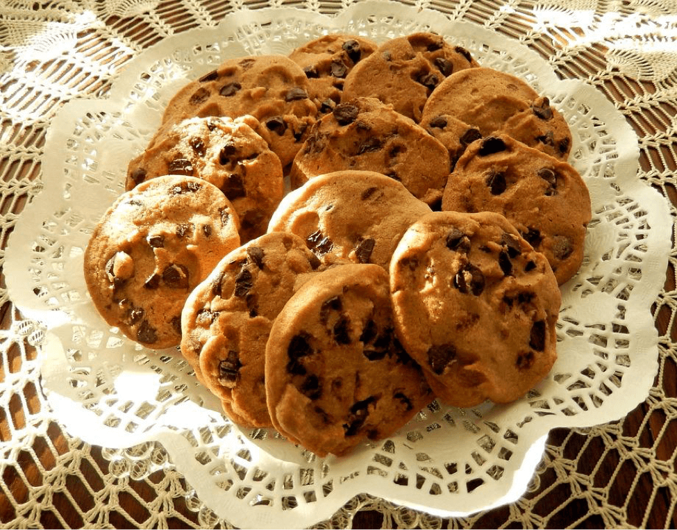 A lace-covered plate holding oatmeal chocolate chip cookies.