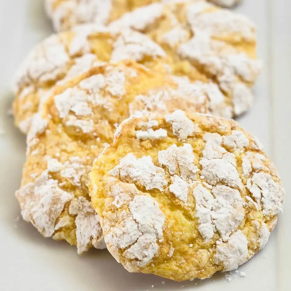 A front table view of a line of Lemon Snowflake Cookies on a white tray.