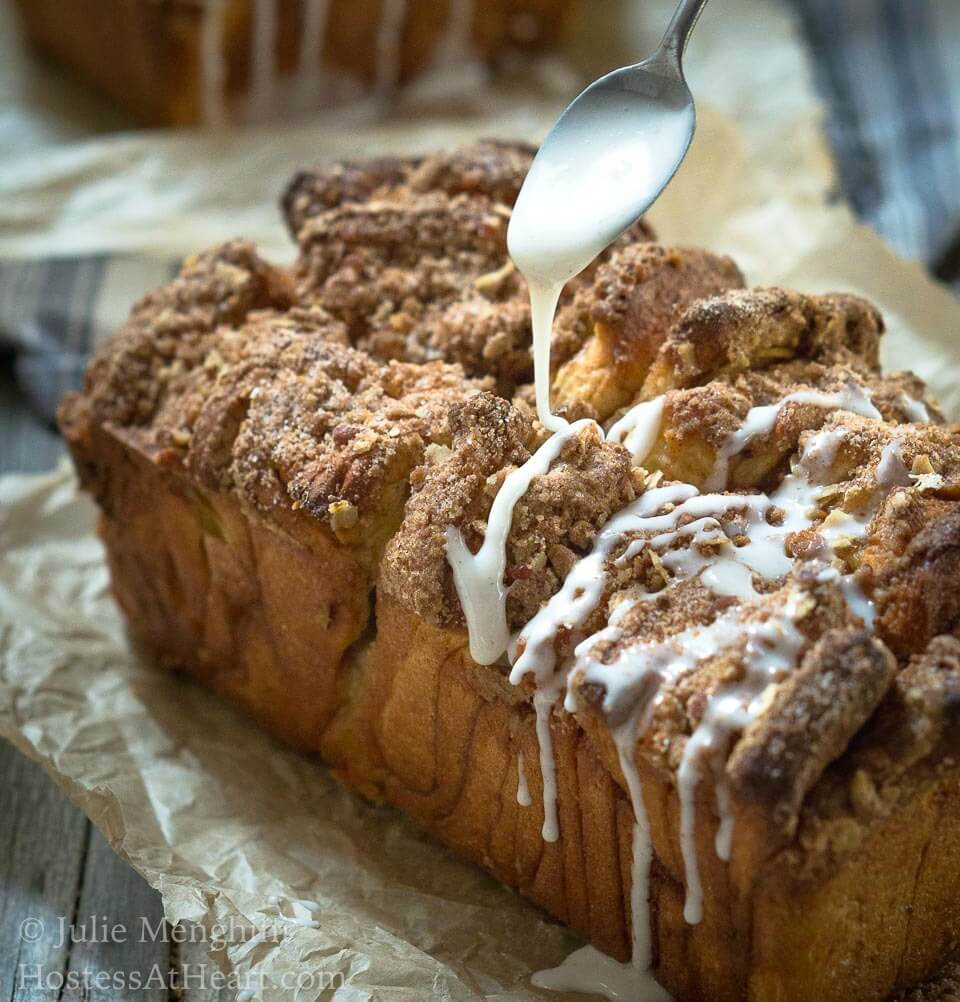 Loaf of Apple Pecan Streusel Pull Apart Bread with glaze drizzle
