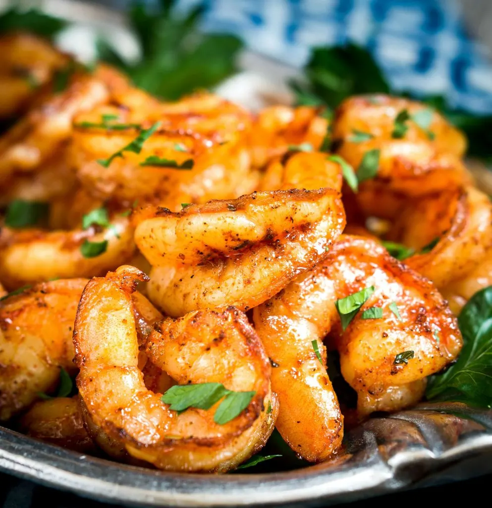 Baked Blackened Shrimp piled on a plate and garnished with fresh parsley