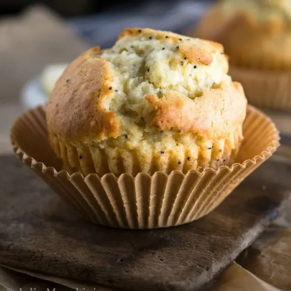 Muffin sitting in a muffin paper on a wooden butter paddle