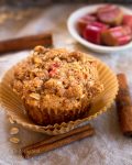 top view of a Rhubarb Oat Muffin with raw pieces of rhubarb in a bowl
