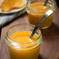 Two jars of Peach Sauce with spoons