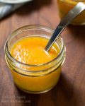 Close up of one jar of Peach Sauce with spoon