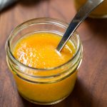 Close up of one jar of Peach Sauce with spoon
