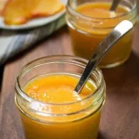 Close up of two jars of Peach Sauce with spoons