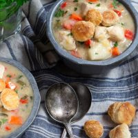 Closer to view of two bowls Chicken Pot Pie Soup with croutons and spoons