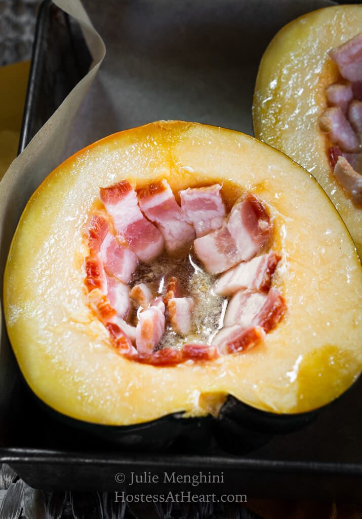 Raw half of an acorn squash stuffed with bacon