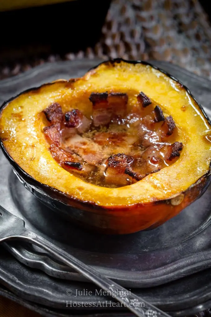 3/4 view of top side of a baked acorn squash filled with bacon
