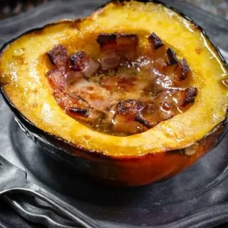 Half of a baked acorn squash filled with bacon