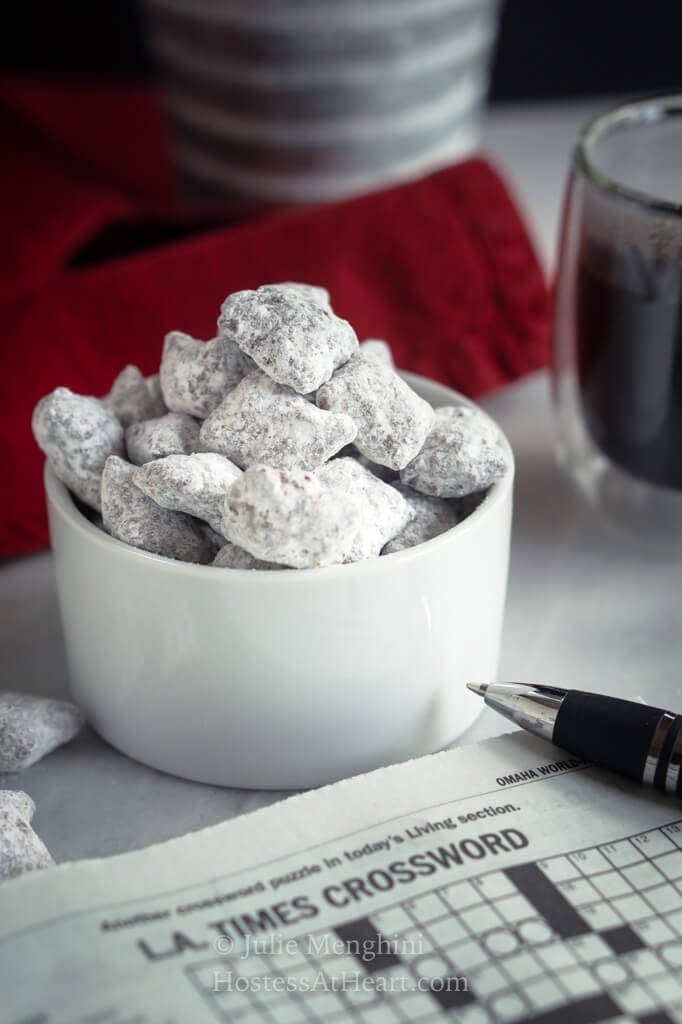 Close up shot of puppy chow with a cup of coffee and crossword puzzle