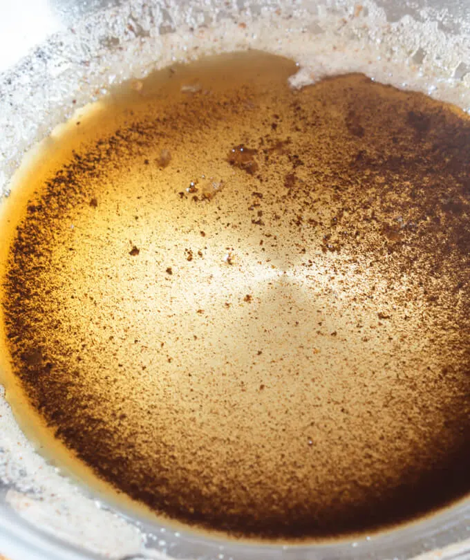 Pan of golden browned butter shows the milk solids that are browned and sink to the bottom of the pan