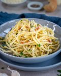 This bowl of creamy bucatini Cacio de Pepe pasta is full of cheese, prosciutto and parsley dotted with toasted garlic and black pepper