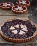 A beautiful dark sweet cherry torte with three bright red cherry mini tarts