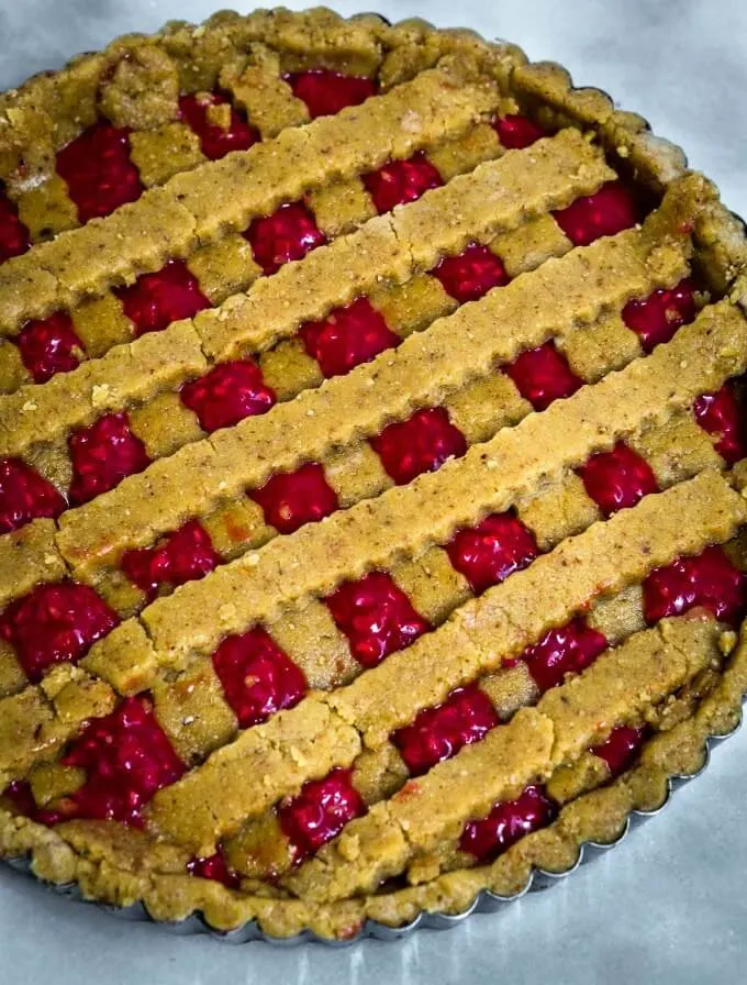 Top-down view of a raspberry tart with a lattice top.