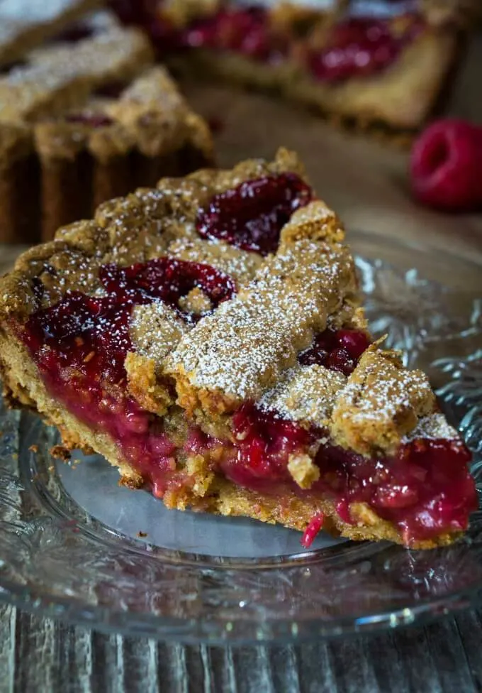 This slice of a Raspberry Linzer tort has a mound of sweet cherry filling nestled between an almond pastry shell. 