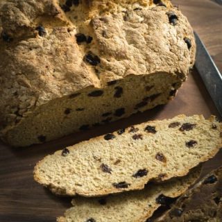 Easy Soda Bread with Raisins is a browned round loaf of dense bread dotted with raisins
