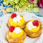 3 puff pastry baskets filled with lemon pudding and topped with whipped cream and a raspberry.