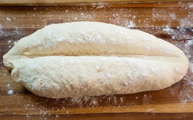 Rolls are shaped into a short baguette and then creased down the center
