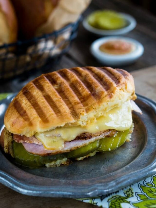 Image of a panini pressed cubano sandwich filled with pork, cheese, and ham