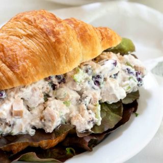 Croissant sandwich stuffed with chicken salad loaded with craisins, celery and green onion