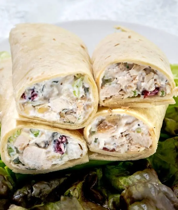 4 wraps stacked together stuffed with chicken salad dotted with crasins, celery and onion