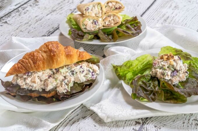 Chicken salad served in a croissant, wrap and on a bed of lettuce.