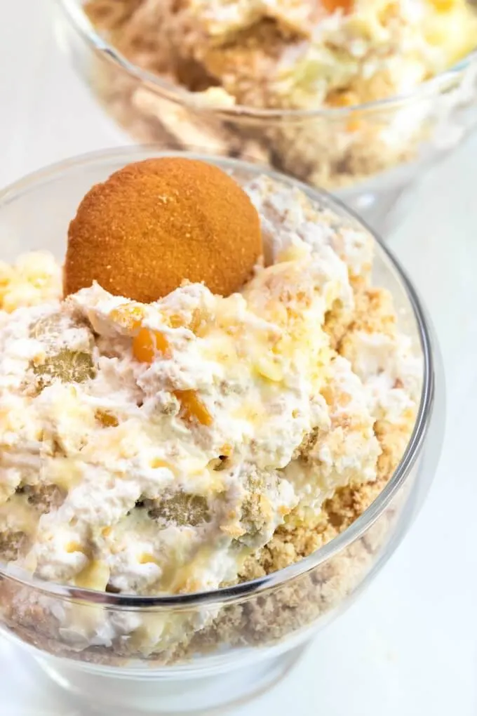 Top-down view of a dessert dish filled with creamy fruit-filled whipped topping, pudding, and Nilla cookie crumbs all topped with a Nilla cookie.