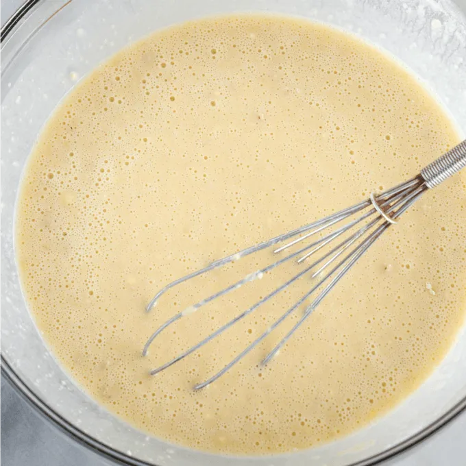 Mix of yeast, liquid and sugar start to bubble when activated with a whisk in a glass bowl