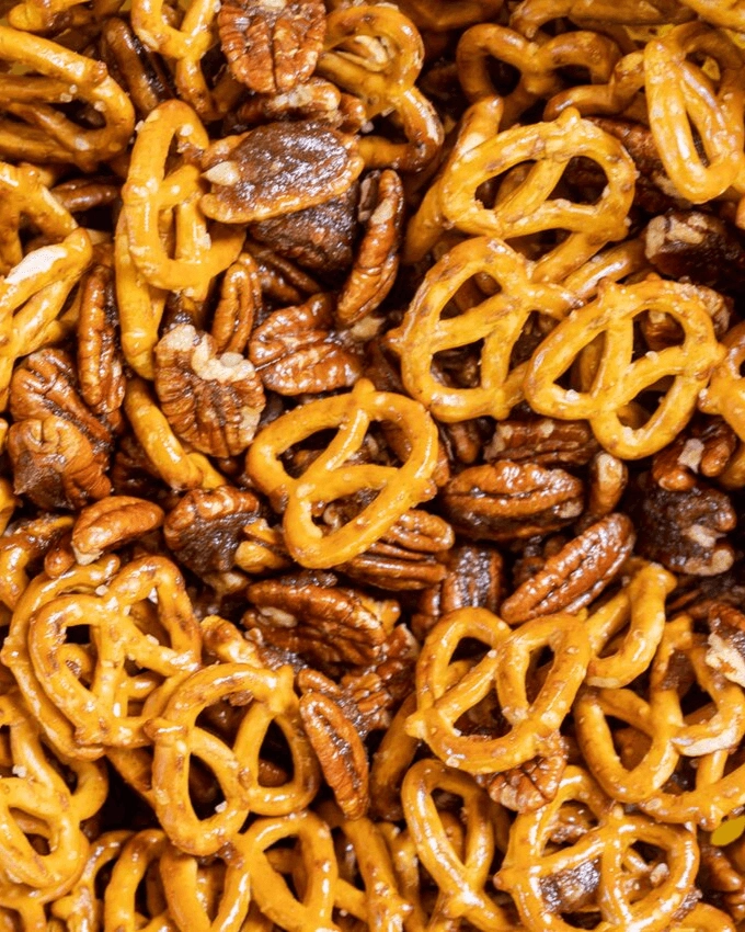 Close up of pretzels and pecans mixed with melted butter and brown sugar.