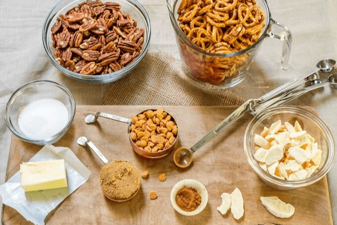 Ingredients of Apple Pie Snack mix including pretzels, pecans, dried apples, brown sugar, cinnamon, butter and caramel chips