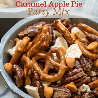 Close up view of pretzels, pecans, caramel chips and dried apples mix in a bowl on a blue striped napkin
