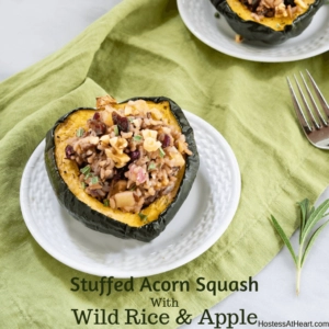 Half of an Acorn Squash stuffed with wild rice and apples on a white plate sitting over a green napkin with the recipe title across the bottom of the photo