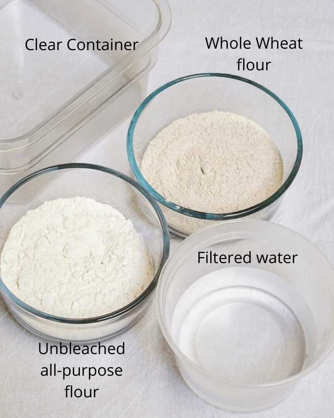 two bowls of flour, a bowl of water and a mixing bowl