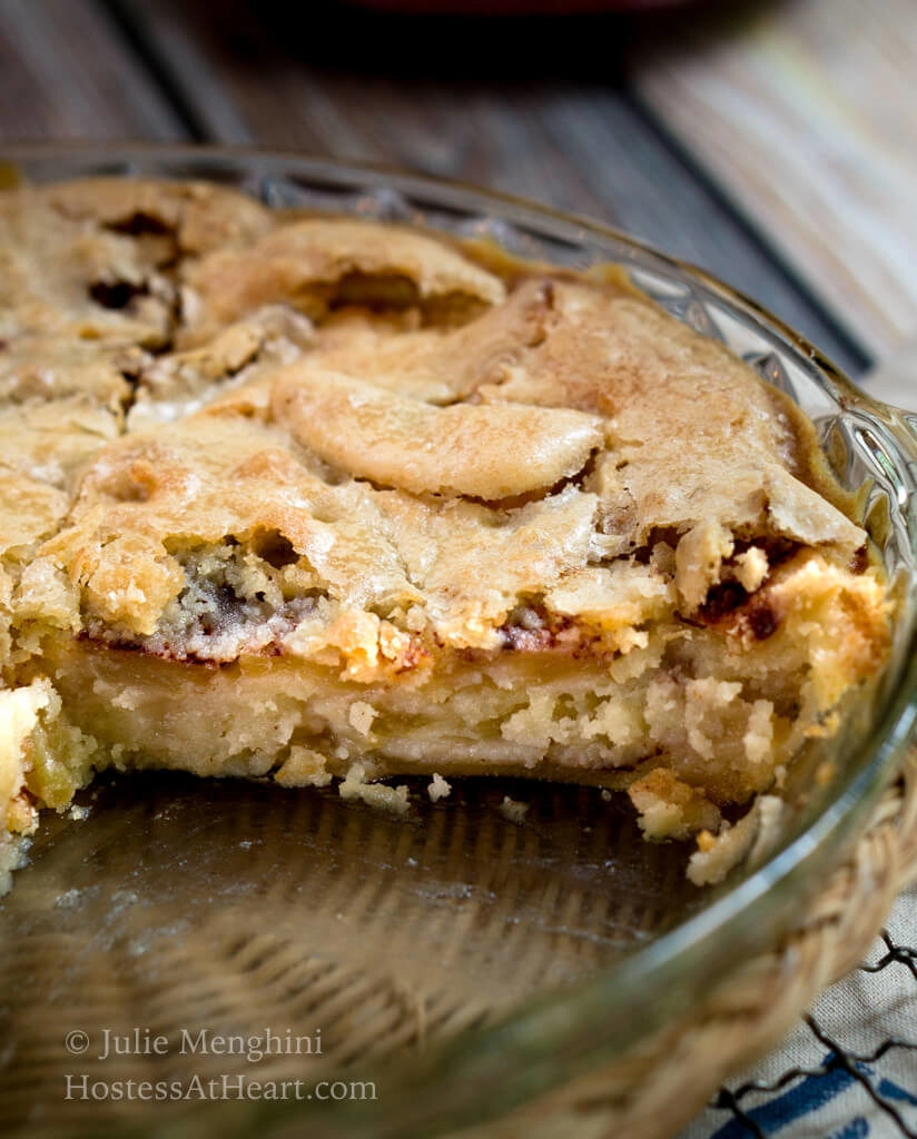 Pie Plate with a large piece of Swedish Apple pie cut from it showing an apple-cinnamon filling and a flaky topping.