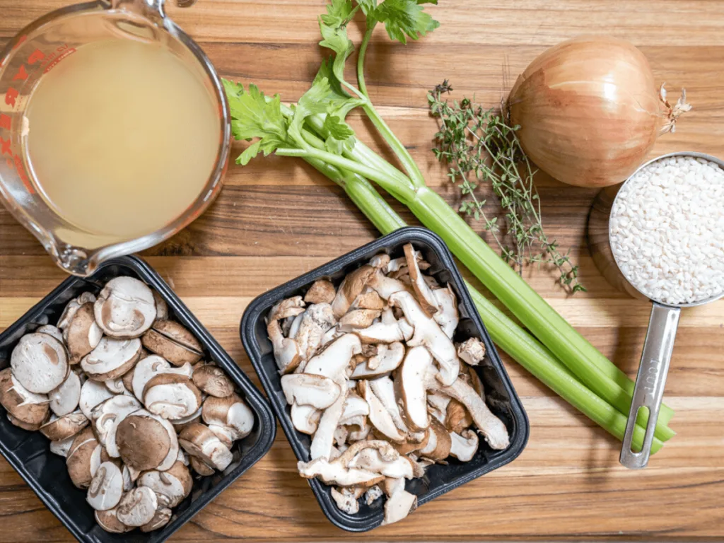 Ingredients for mushroom risotto including chicken stock, celery, onion, mushrooms, rice and fresh thyme