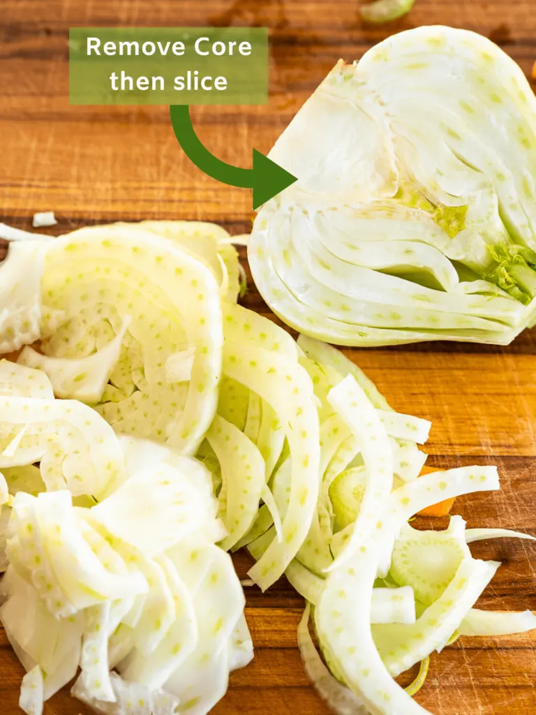 A sliced fennel bulb on a wooden cutting board with an arrow instructing to rmove the core.