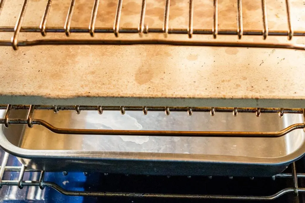 Photo showing how the oven is set up for baking sourdough sandwich bread. The middle grate holds a baking stone and the lower grate holds a broiler pan.