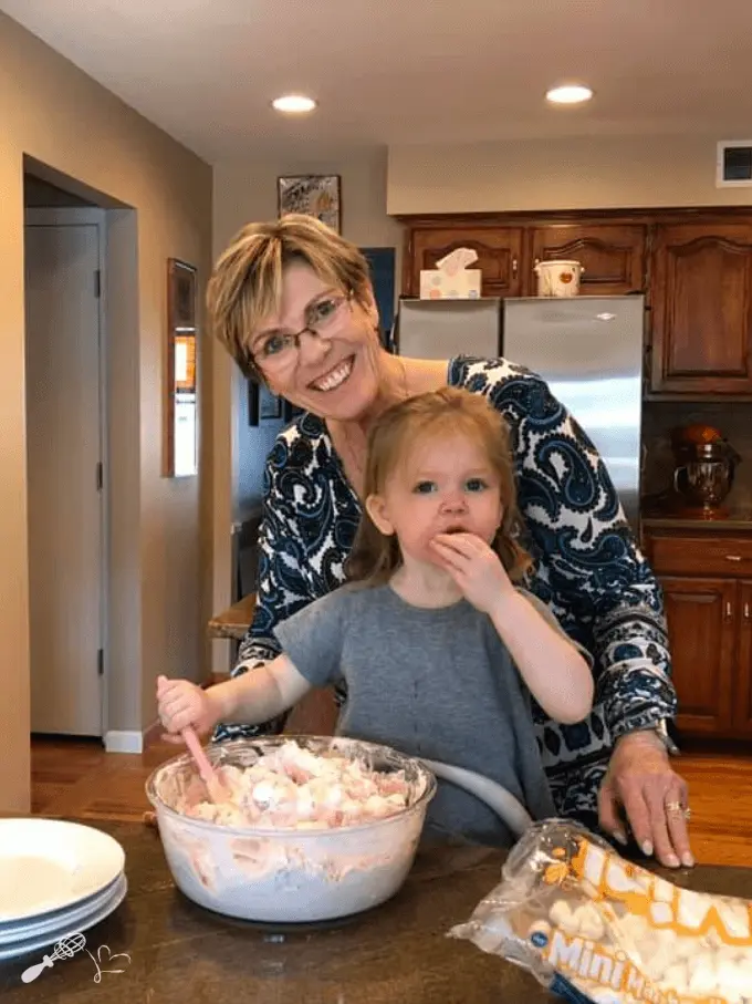 Photo of myself with my granddaughter making a big bowl of pink fluff. She's eating the marshmallows instead of stirring them into the bowl of fluff.