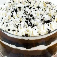 Top angle photo of a chocolate cake trifle showing several layers of cake, pudding, whipped cream and cookie crumbs in a tall trifle bowl.