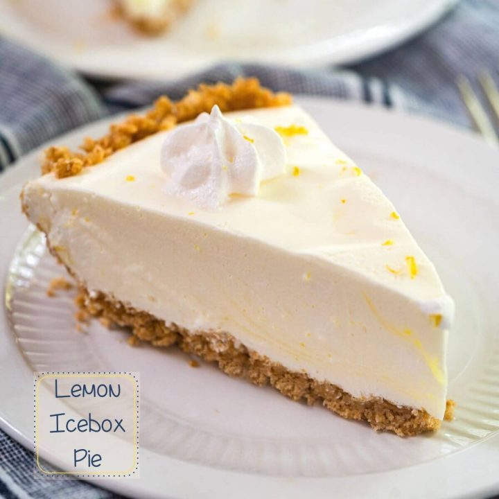 Close up side view of a slice of Lemon Icebox Pie. The slice has a thick graham cracker crust topped with a cool creamy layer and topped with a star of cool whip topping. The slice sits on a white plate over a blue napkin and the recipe title is in the left bottom corner.