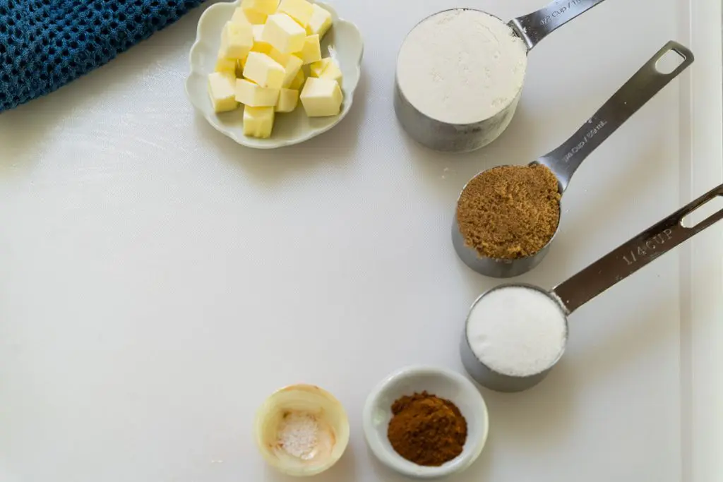 Ingredients used in making the crisp in the peach crisp dessert including butter, flour, brown sugar, sugar, cinnamon, and salt.