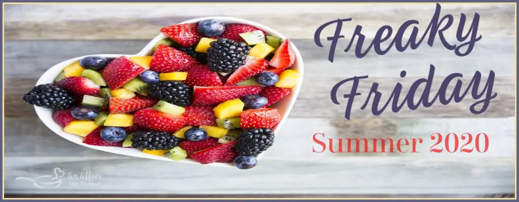 Sign for a Freaky Friday Summer 2020 Blog Hop that has a top-down photo of a white heart-shaped bowl filled with mixed fruit.
