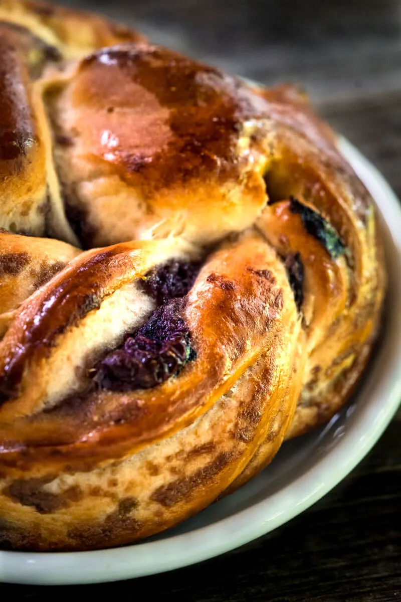 Close-up view of a Blueberry Twist Roll sitting on a white plate.