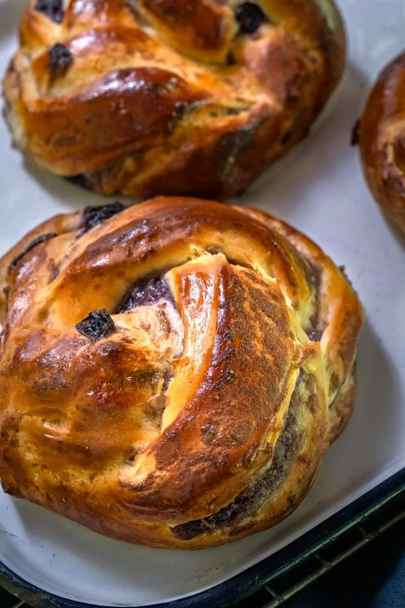 Close-up view of a Blueberry Twist Roll sitting on a white plate.