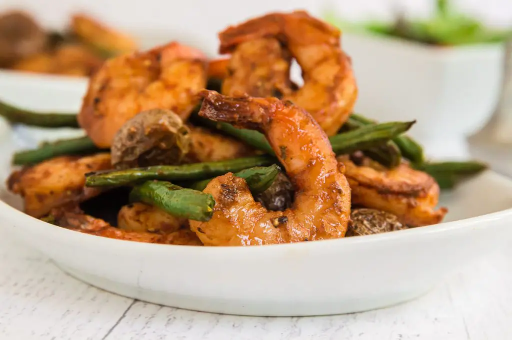 Side view of shrimp and green beans in a bowl