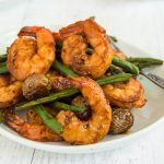 Side view of cooked shrimp, potatoes and Green beans in a bowl.