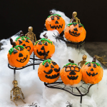 Chocolate cake shaped like pumpkins with Jack o Lantern faces surrounded by spider web, spiders and skeletons.