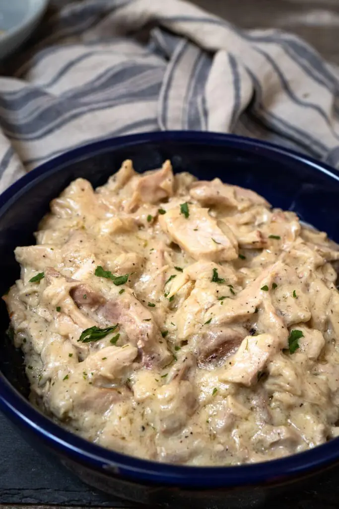 Blue bowl filled with creamy hot turkey filling for hot turkey sandwiches.